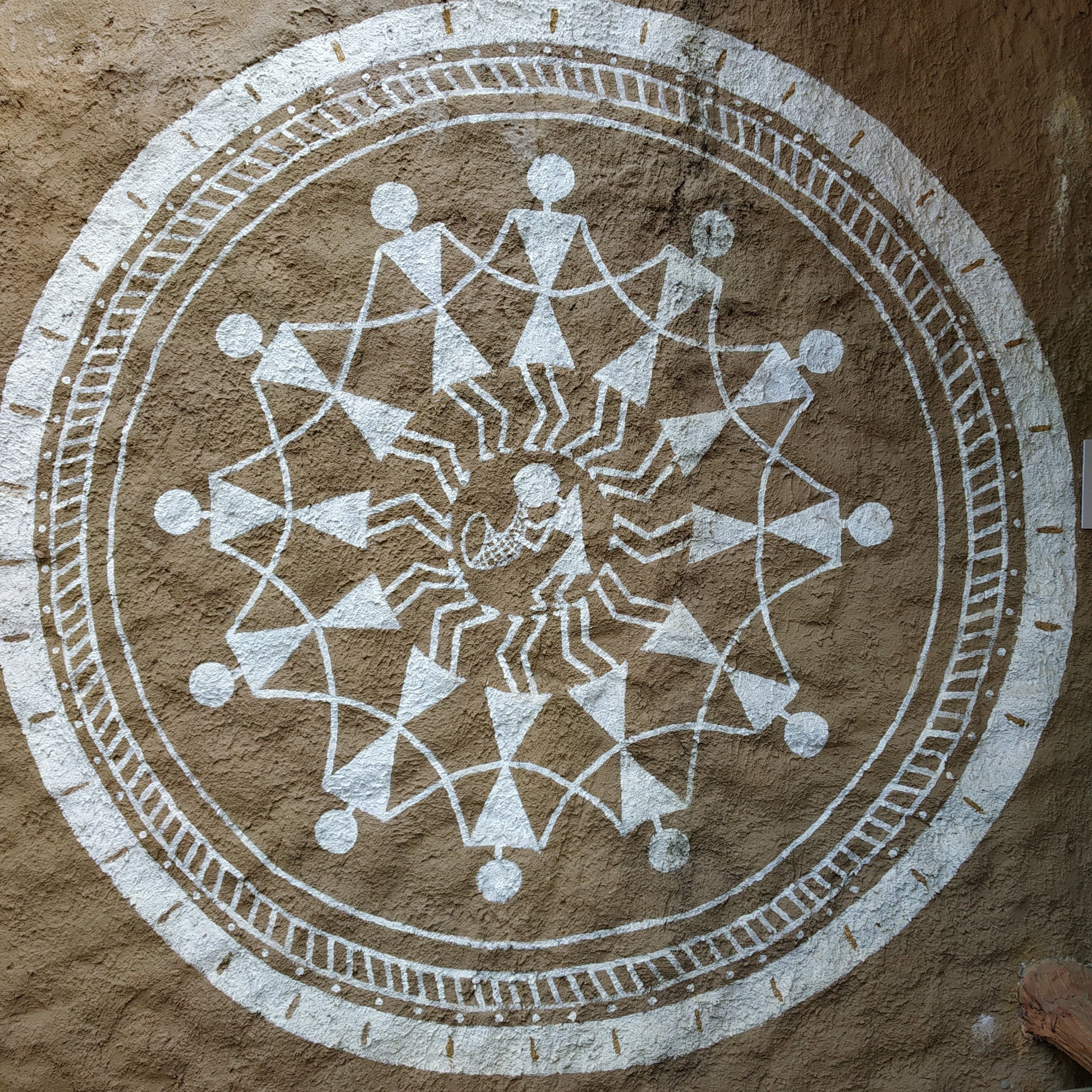 Warli painting depicting the tarpa dance, musicians and dancers in a circle