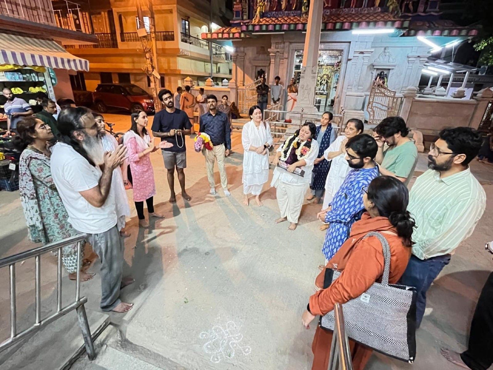 A small group of devotees gathered together with the murti, near the start of the walk